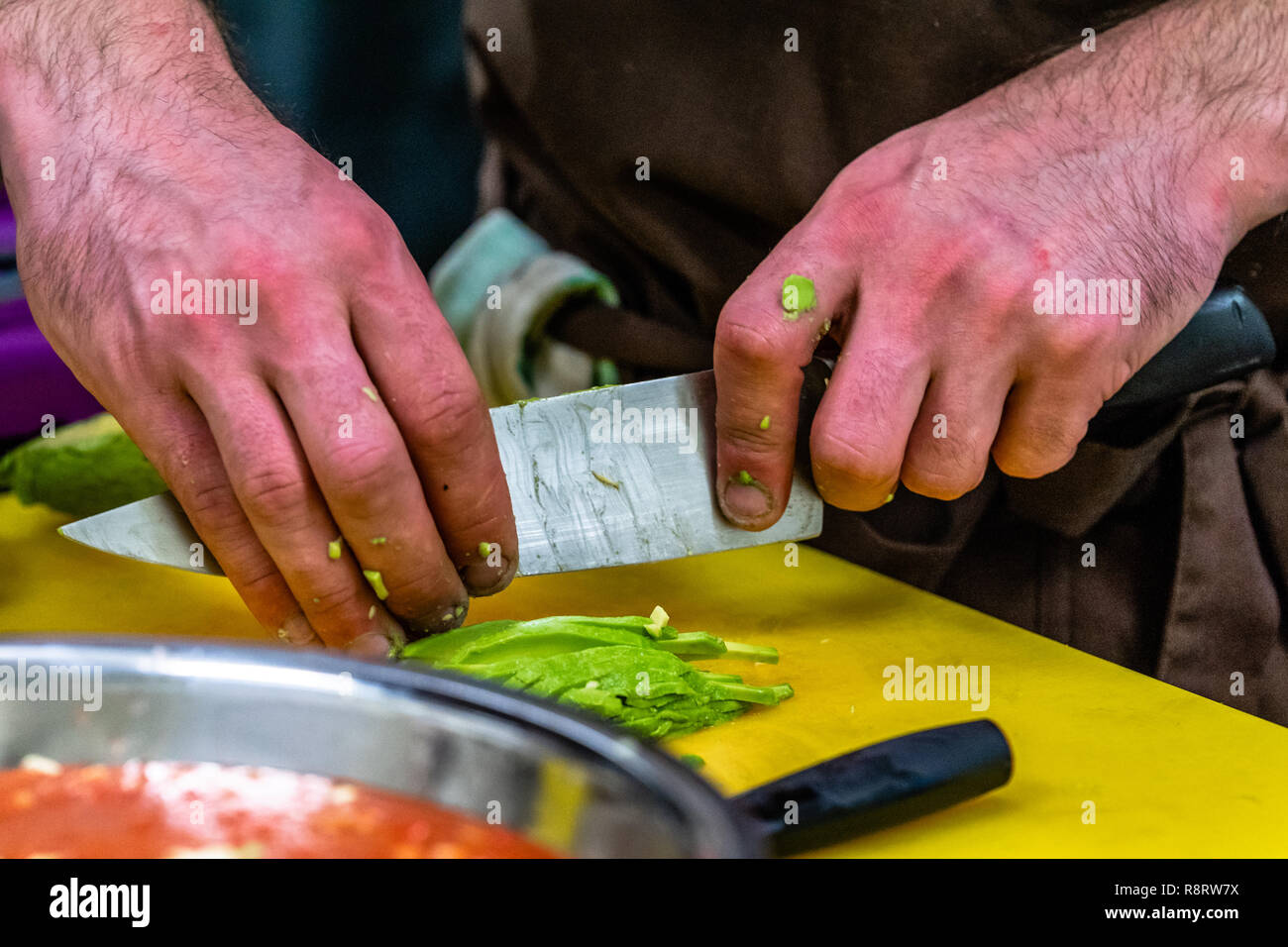 Male Chef Slicing Avocado for  Wedding Meal - Kitchen Set with Isolated Action, Only Chef`s Hands Stock Photo